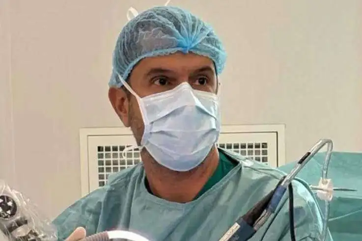 Dr. Ricardo Bastos in surgical scrubs during an operation